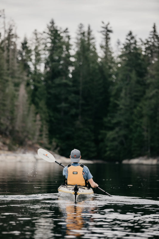 Waterproof dry bag packed with paddling gear near the water