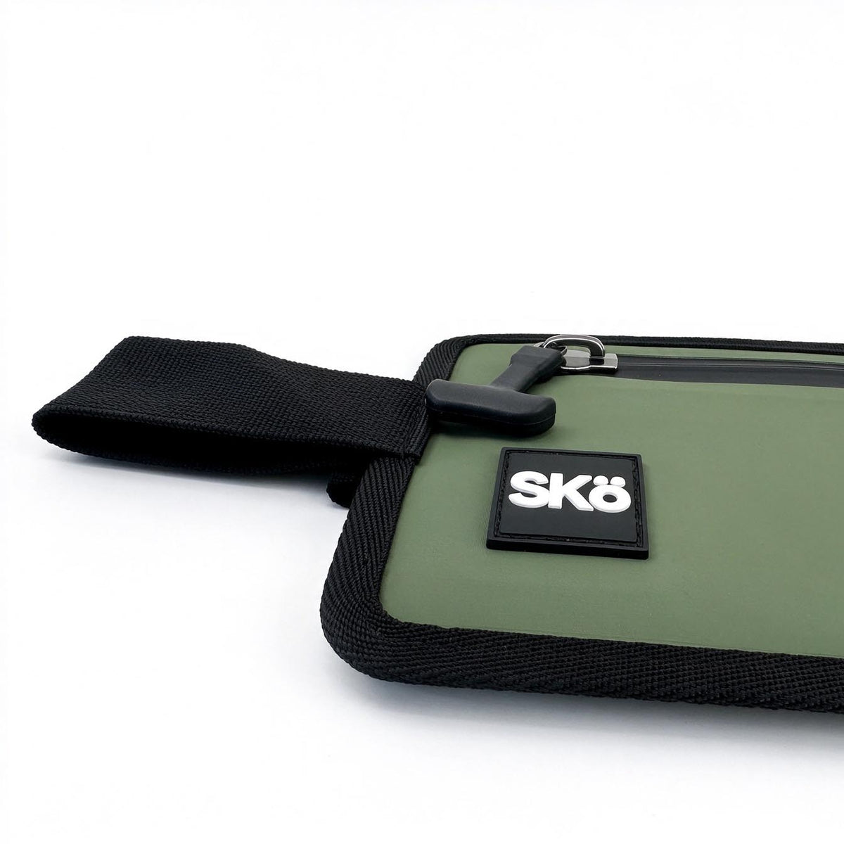 Phone Pouch in Olive Green, close-up of the white SKÖ logo, rubberized pull tab and black woven edging.