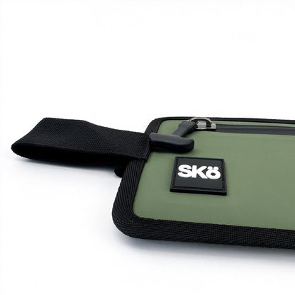 Phone Pouch in Olive Green, close-up of the white SKÖ logo, rubberized pull tab and black woven edging.