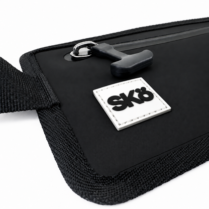 Phone Pouch in Matte Black, detail of the sealed zipper pull, stitched black edging and white square SKÖ logo.
